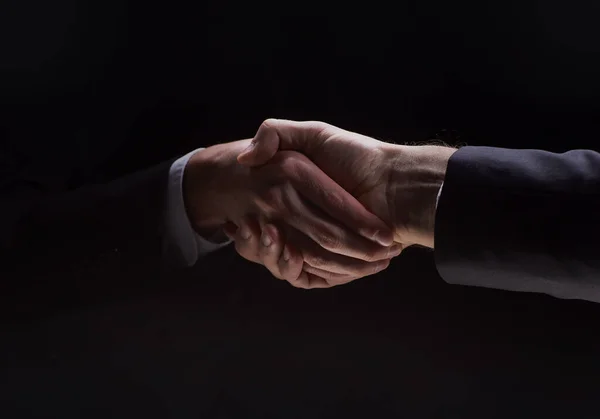 Photo Two Men Suits Shaking Hands Black Background — Zdjęcie stockowe