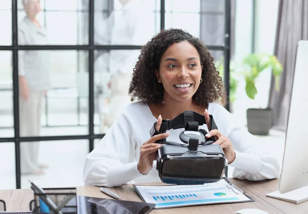 woman testing VR glasses or goggles sitting in the office room