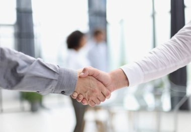Close up people shaking hands on blurred background