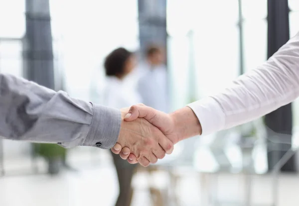 Close up people shaking hands on blurred background