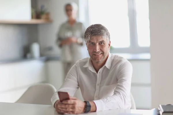 successful businessman holding a phone in his hand in the office