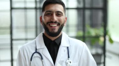 Doktor ceketi giyen, kendine güvenen, akıllı yüzlü bir adam.