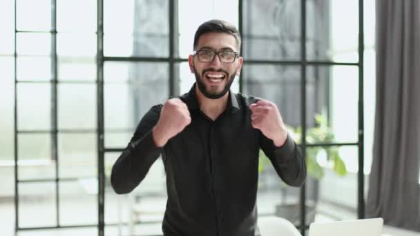 Siyah Gömlekli Yakışıklı Adam Yumruklarını Kaldırmış Ofiste Başarıyı Kutluyor — Stok video