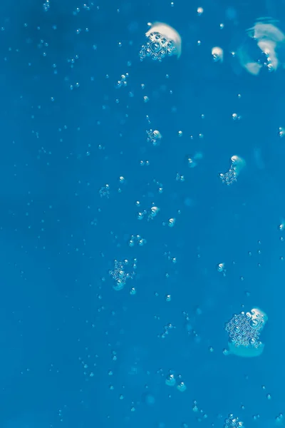 Světlo odrážející se ve vodě se vzduchovými bublinami a bokeh — Stock fotografie