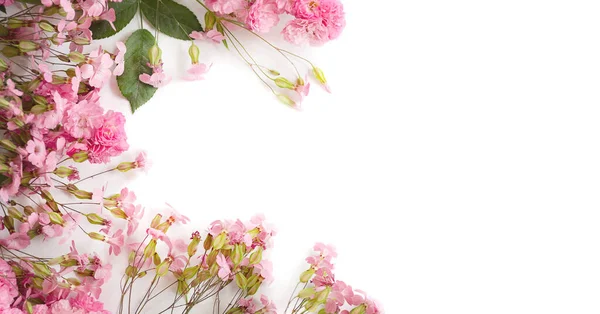 Fondo loral con flores y brotes de color rosa en forma de marco con un lugar para el texto — Foto de Stock