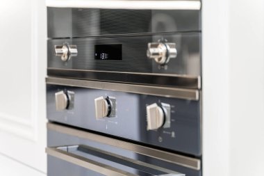 Siyah tezgahı ve beyaz aletleri olan yeni şık bir mutfak. Siyah beyaz dolap kapıları.