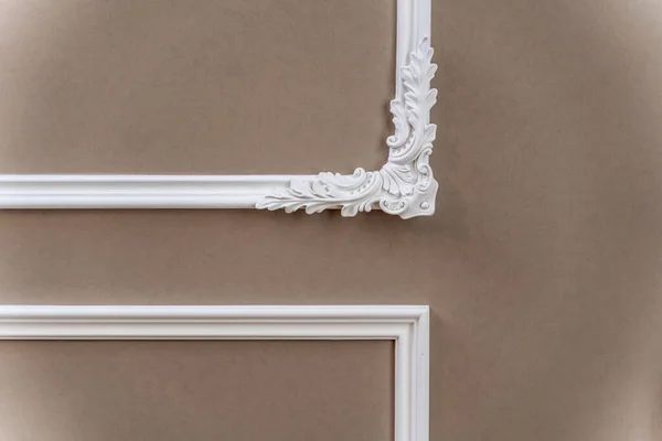 Panel, odanın duvarında desenli köşeleri olan alçı bir çerçeve. İç dizayn. Barok elementlerle dolu bir çatı katı. Bej-kahverengi gölgeler.