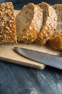 Gri zemin üzerinde dilimlenmiş ekmek parçaları.