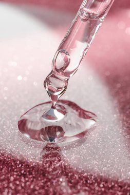 Koyu arkaplanı pembe olan kozmetik pipeti..