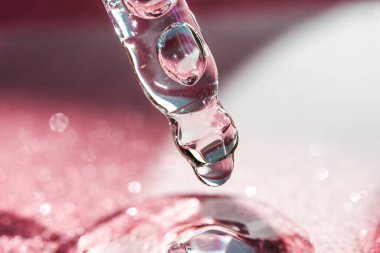 Koyu arkaplanı pembe olan kozmetik pipeti..