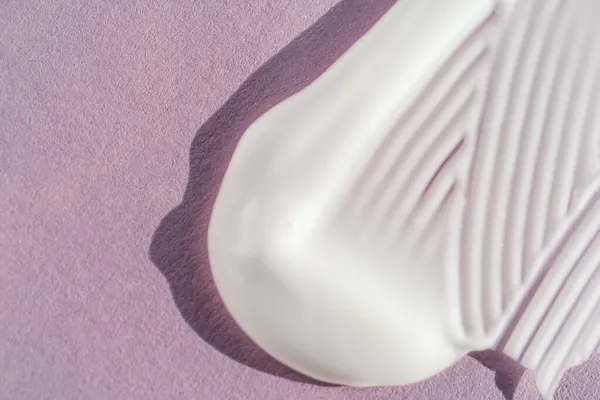 Mor arkaplandaki beyaz kremin dokusu.
