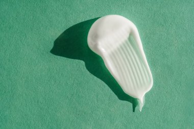 Yeşil arka planda beyaz kremin dokusu.