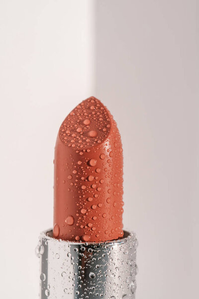 Увлажняющая помада с капельками воды на ней.