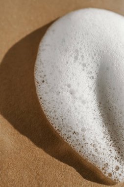 Bej arkaplanda beyaz köpük dokusu.