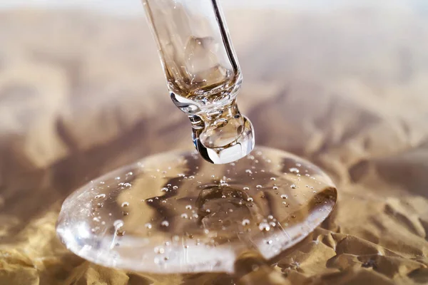 La textura del suero o aceite con una pipeta sobre un fondo beige. —  Fotos de Stock