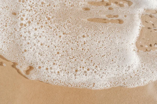 Texture of white foam on a beige background. — Stock Photo, Image