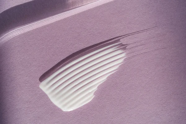 Mor arkaplanda beyaz krema dokusu.