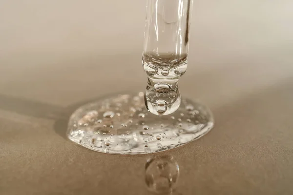 Bej arka planda pipeti olan serumun veya yağın dokusu.