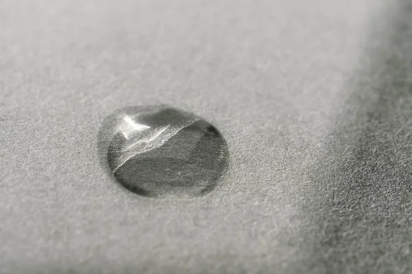 Una gota de producto cosmético sobre un fondo gris. Textura. — Foto de Stock
