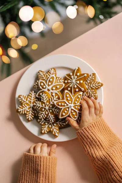 Galletas de Navidad de jengibre en manos de niños en el fondo del árbol de Navidad. — Foto de Stock