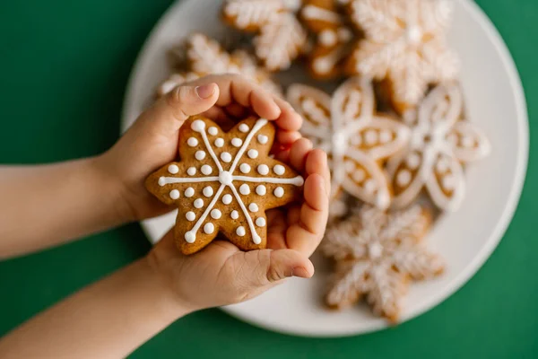 Ingefära jul kakor i barns händer på bakgrunden av julgranen. — Stockfoto