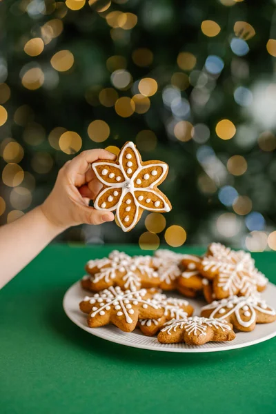 Ingefära jul kakor i barns händer på bakgrunden av julgranen. — Stockfoto