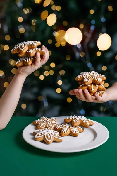 Galletas de Navidad de jengibre en manos de niños en el fondo del árbol de Navidad. — Foto de Stock