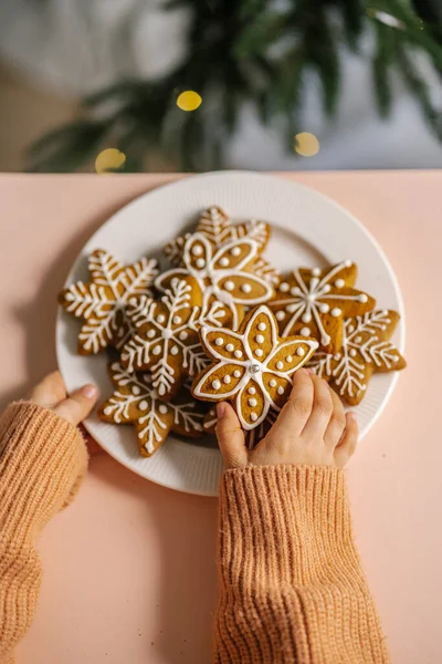 Ingefära jul kakor i barns händer på bakgrunden av julgranen. — Stockfoto