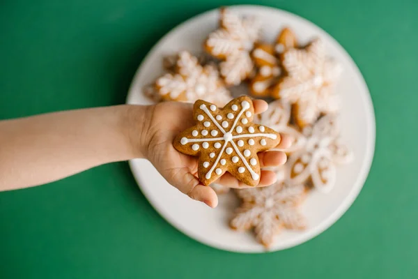 Galletas de Navidad de jengibre en manos de niños en el fondo del árbol de Navidad. — Foto de Stock