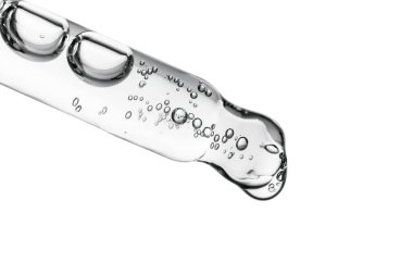 Beyaz izole bir zemin üzerinde kozmetik ürünleri olan şeffaf pipet.