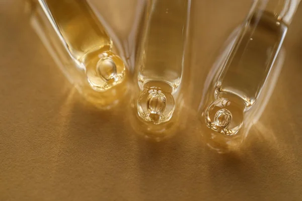 Pipetas con aceite o suero sobre fondo dorado. —  Fotos de Stock
