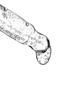 Açık arkaplanda kozmetik ürünleri olan şeffaf pipet.