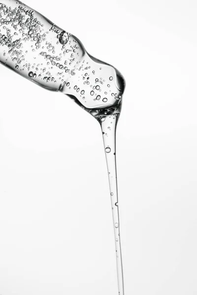 Beyaz izole bir zemin üzerinde kozmetik ürünleri olan şeffaf pipet.