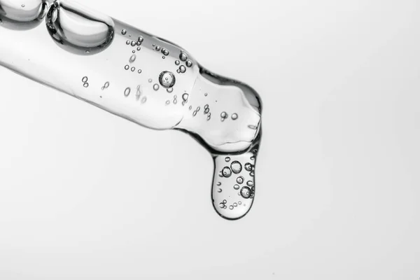 Beyaz izole bir zemin üzerinde kozmetik ürünleri olan şeffaf pipet.