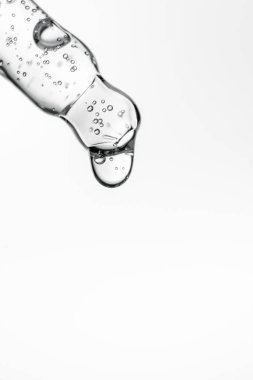 Beyaz izole bir zemin üzerinde kozmetik ürünleri olan şeffaf pipet.