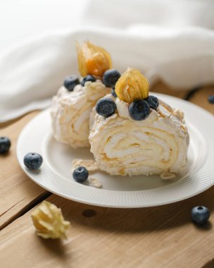 İki parça kremalı pasta ve bir tabak böğürtlen..