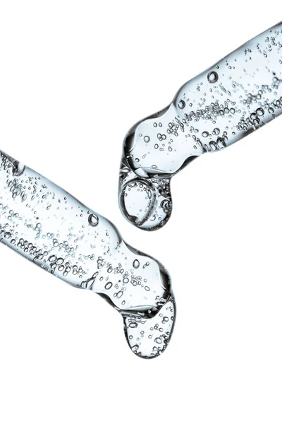 Açık arkaplanda kozmetik ürünleri olan şeffaf pipet.