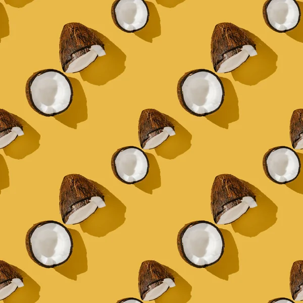 Ein Muster von Kokosnüssen auf leuchtend gelbem Hintergrund. — Stockfoto