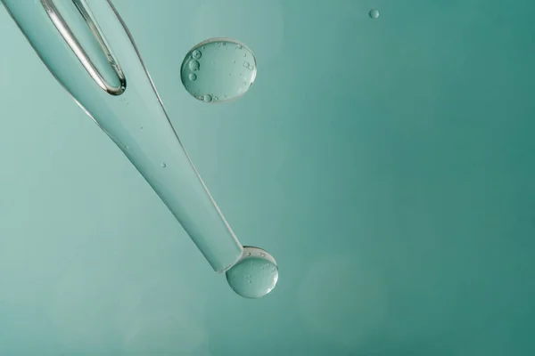 Pipeta com produto cosmético em água com bolhas. — Fotografia de Stock