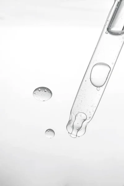 Pipett med kosmetisk produkt i vatten med bubblor. — Stockfoto