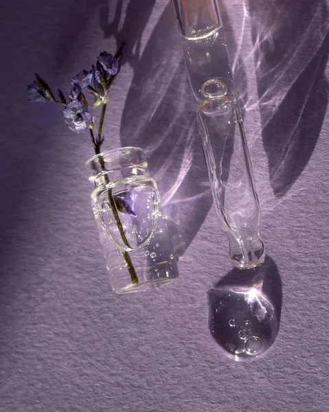 紫色の背景に化粧ジェルとラベンダーのボトル — ストック写真