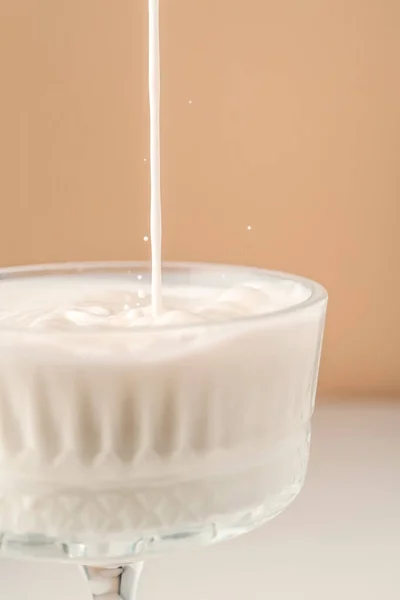 ミルクは美しい結晶ガラスに注ぎ、周りに飛び散る. — ストック写真
