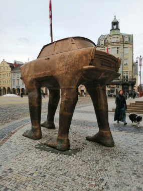 İlginç bir heykel. Belediye binasının önündeki meydanda granit küpleri döşeyen dev bir Trabant heykeli ve yanından geçen köpekli bir kadın.. 