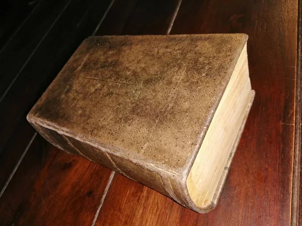 Antique big book. Massive nostalgic leather - bound book lying on a dark wooden background.