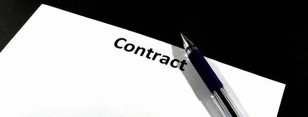 Yazı sözleşmesi olan boş bir sayfa. İmza kaleminin yanında. Sözleşmenin sonu