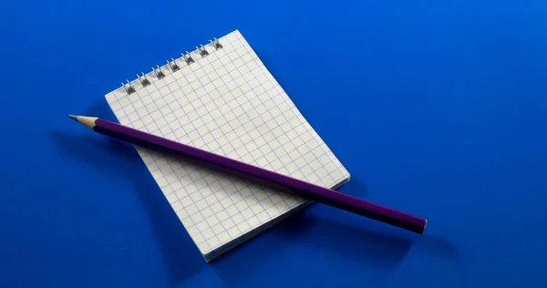 Ein Leeres Notizbuch Und Bleistift Auf Blauem Hintergrund — Stockfoto