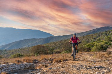 İtalya 'nın Toskana Takımadası' ndaki Elba Adası 'nda Akdeniz kıyısında elektrikli dağ bisikletine binen hoş bir kadın.
