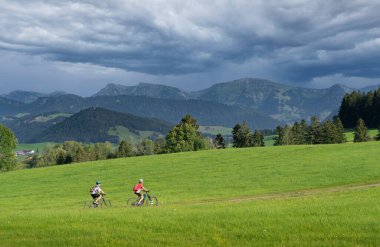 Almanya, Bavyera 'da Oberstaufen yakınlarındaki Allgaeu Alplerinde elektrotlu dağ bisikletlerine binen genç büyükanne ve torunu olarak kaldılar.