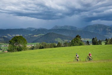 Almanya, Bavyera 'da Oberstaufen yakınlarındaki Allgaeu Alplerinde elektrotlu dağ bisikletlerine binen genç büyükanne ve torunu olarak kaldılar.
