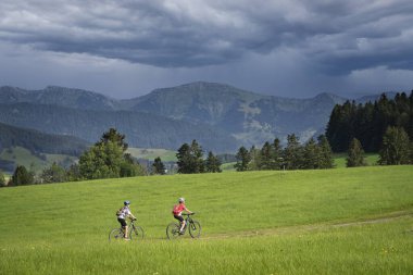 Almanya, Bavyera 'da Oberstaufen yakınlarındaki Allgaeu Alplerinde elektrotlu dağ bisikletlerine binen genç büyükanne ve torunu olarak kaldılar.